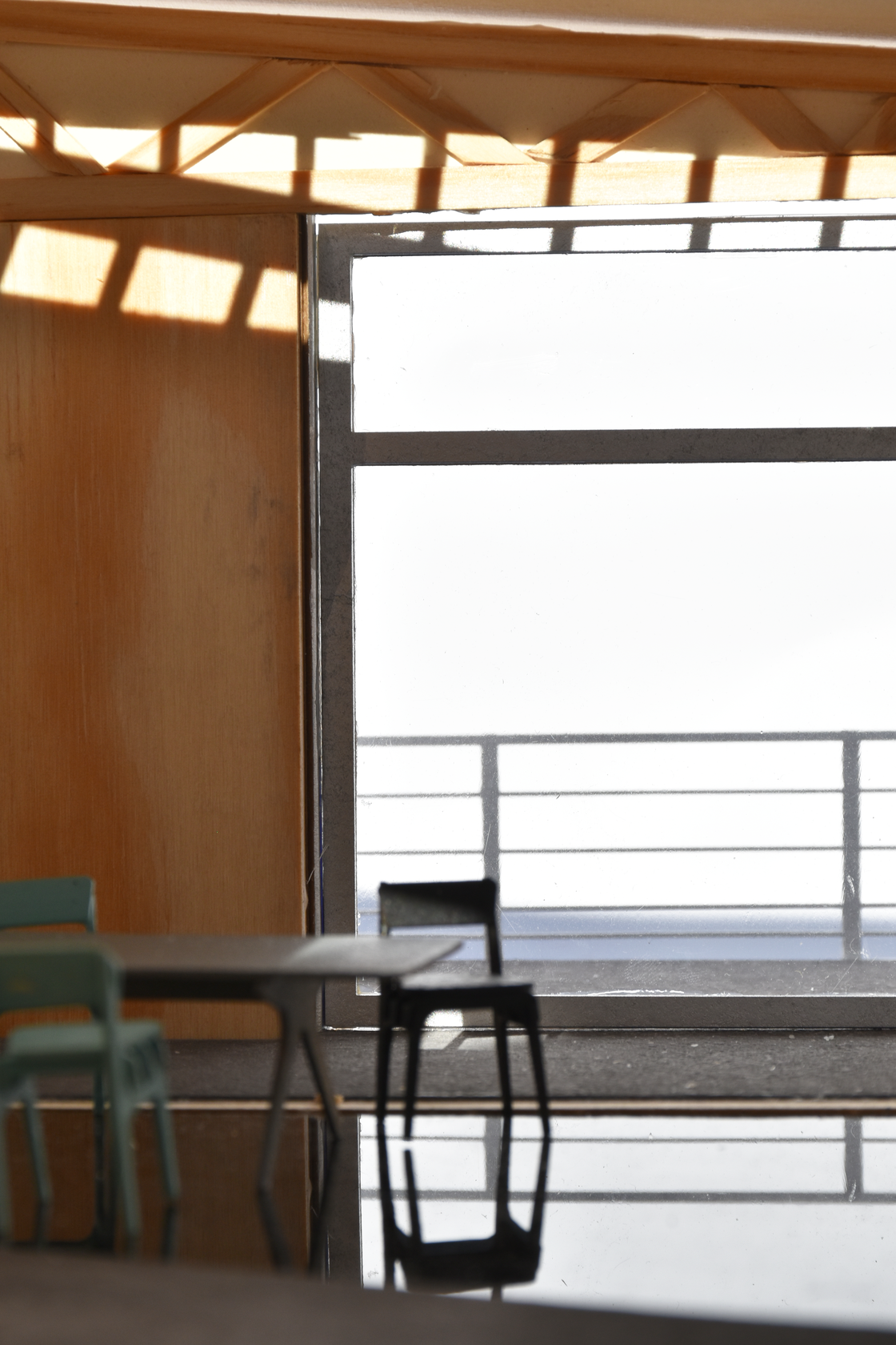 Modern interior view from an architectural model, showcasing a timber structure with a balcony that lets in natural light, possibly reminiscent of an AMAA Workshop interior design, highlighting airy and open spaces.