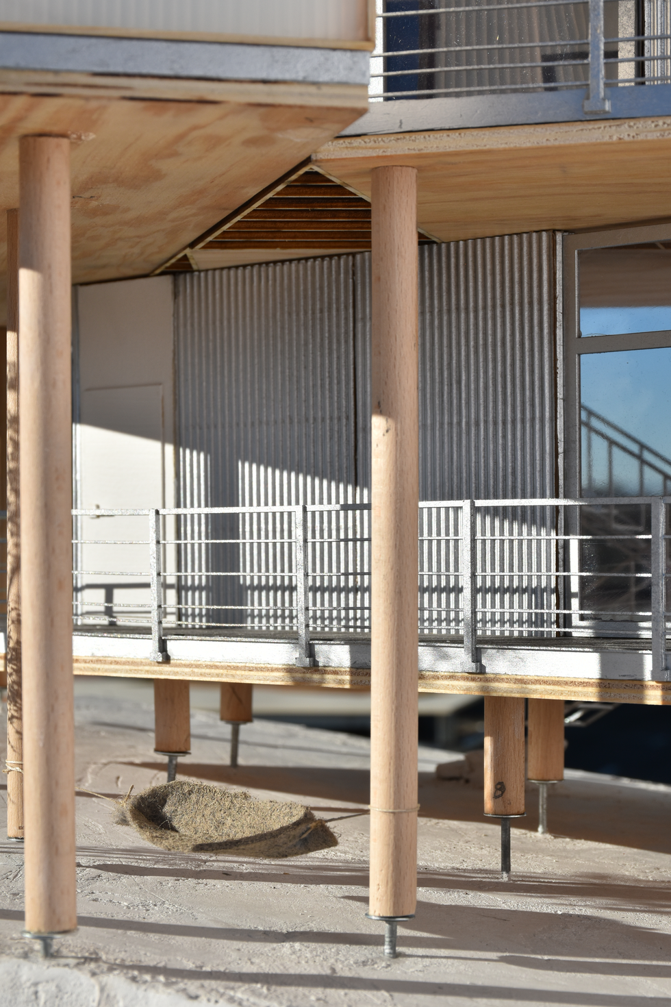 Architectural model detailing an elevated timber frame construction, emphasizing its structural elements